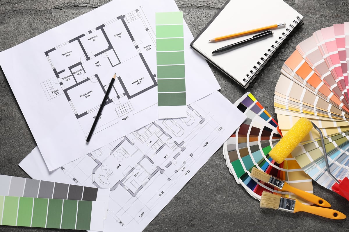 House plans and decorator tools laid out on a table during project planning