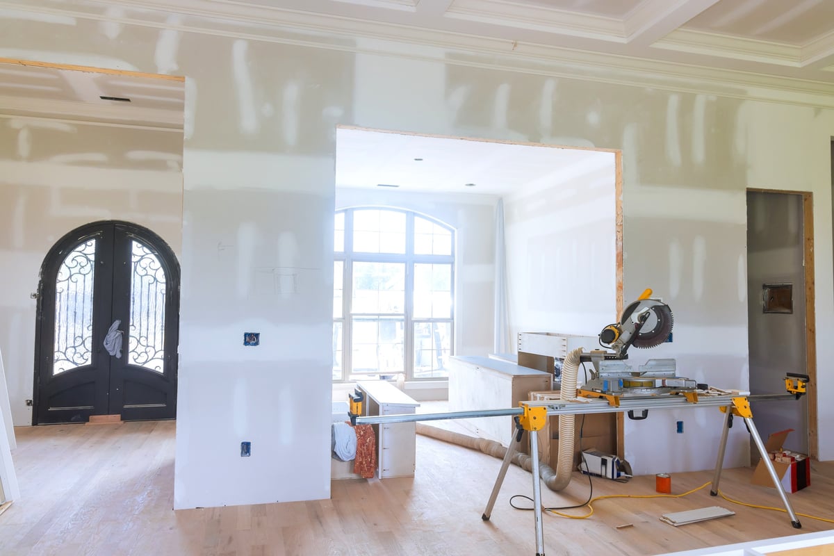 A modern living space being prepared during a home renovation, with tools and freshly framed walls